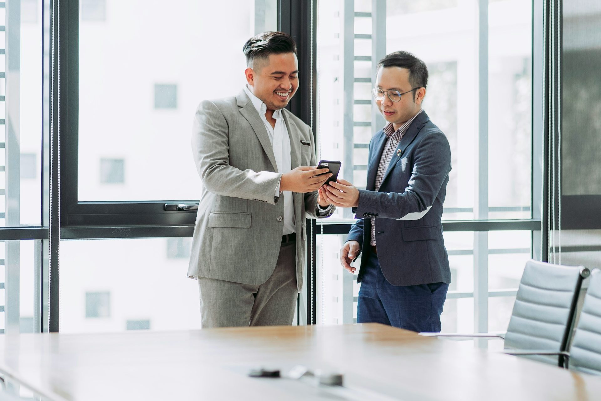 two men shaking hands in a conference room